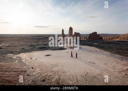 Mère et fils aux ruines à couper le souffle de la forteresse de Jampik Kala située dans le désert de Kyzylkum dans la région de Karakalpakstan en Ouzbékistan Banque D'Images