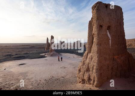 Mère et fils aux ruines à couper le souffle de la forteresse de Jampik Kala située dans le désert de Kyzylkum dans la région de Karakalpakstan en Ouzbékistan Banque D'Images