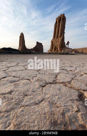 Femme en veste jaune debout à couper le souffle ruines de la forteresse Jampik Kala situé Kyzylkum désert dans Karakalpakstan région de l'Ouzbékistan Banque D'Images