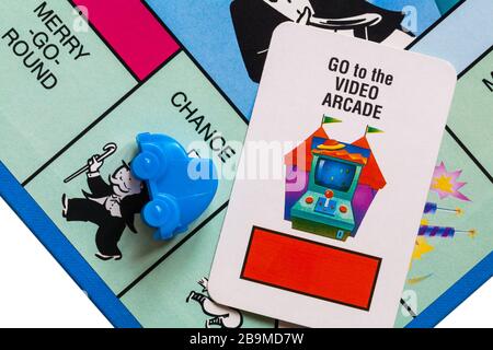 Jeu de société Junior Monopoly - détail du jeton de voiture bleu sur la place chance, avec aller à la carte de chance d'arcade Banque D'Images