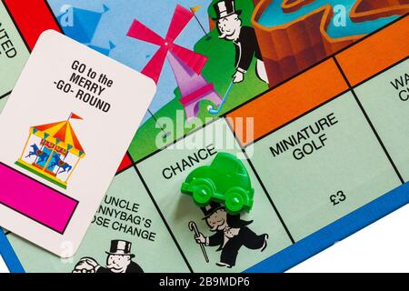 Jeu de société Junior Monopoly - détail du jeton de voiture verte sur la place chance, avec aller à la carte de chance de manège Banque D'Images