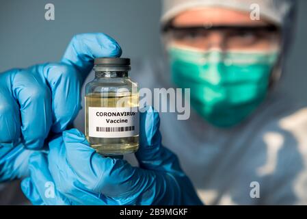 Les hommes scientifiques avec combinaison de protection détiennent un vaccin contre le coronavirus. Homme caucasien avec vaccination pour COVID-19. 2019-nCoV trouvé dans Wuhan Chine. EPI Banque D'Images