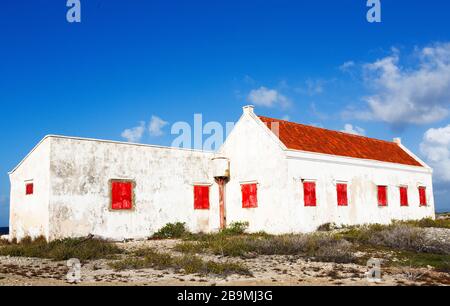 Ancienne maison blanche abandonnée avec volets de fenêtre rouge sur la côte de Bonaire partie des îles ABC, Pays-Bas Antillies, Caraïbes Banque D'Images