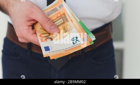 Détail des mains de l'homme avec de l'argent, billets en euros Banque D'Images