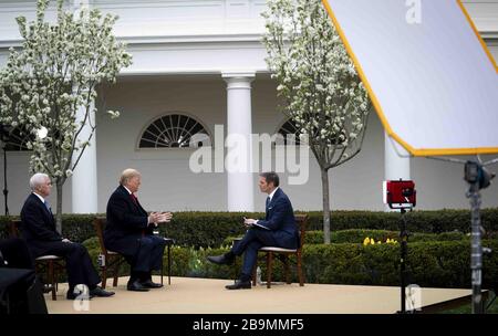 Washington, États-Unis. 24 mars 2020. Le président Donald Trump et le vice-président Mike Pence participent à l'hôtel de ville virtuel de Fox News sur le Coronavirus avec l'ancre Bill Hemmer, dans le jardin des roses de la Maison Blanche le mardi 24 mars 2020. Plusieurs ancres de Fox News ont tenu une discussion avec le président Trump et les membres de son groupe de travail sur le virus et le plan de relance économique en cours de débat sur Capitol Hill. Trump a déclaré qu'il voulait que le « pays ouvert » à Pâques malgré les avertissements des responsables de la santé publique. Photo de Doug Mills/UPI crédit: UPI/Alay Live News Banque D'Images