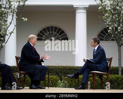 Washington, États-Unis. 24 mars 2020. Le président Donald Trump participe à une mairie virtuelle de Fox News sur le Coronavirus avec l'ancre Bill Hemmer, dans le jardin des roses de la Maison Blanche le mardi 24 mars 2020. Plusieurs ancres de Fox News ont tenu une discussion avec le président Trump et les membres de son groupe de travail sur le virus et le plan de relance économique en cours de débat sur Capitol Hill. Trump a déclaré qu'il voulait que le « pays ouvert » à Pâques malgré les avertissements des responsables de la santé publique. Photo de Doug Mills/UPI crédit: UPI/Alay Live News Banque D'Images