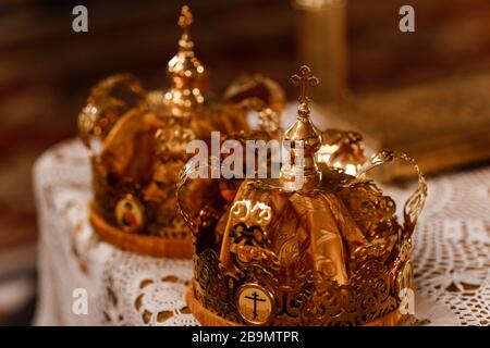 Mariage des couronnes d'or sur la table dans l'église. Couronnes de mariage dans l'église prêtes pour la cérémonie de mariage. Gros plan. Liturgie divine. Banque D'Images