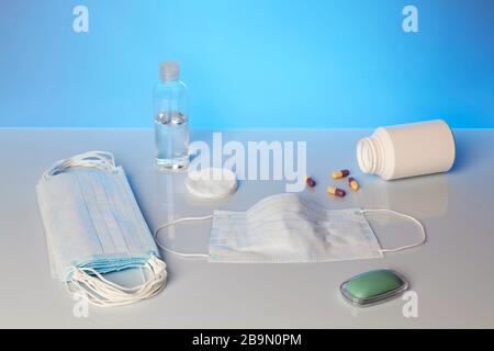 Prévention de la prévention de l'épidémie de maladies virales. Une barre de savon, d'alcool et un masque médical sur fond bleu Banque D'Images