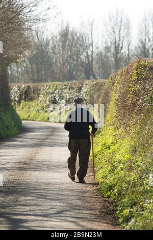 Un homme qui se promenait le matin sur une voie de pays après que le Premier ministre britannique Boris Johnson ait annoncé des restrictions pour contrer la menace de la Co Banque D'Images