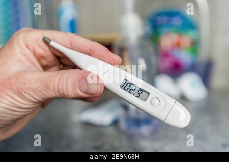 Gros plan du thermomètre à main mesurant une forte fièvre. Banque D'Images