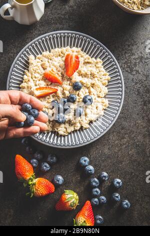 Assiette de porridge de flocons d'avoine avec fraises et bleuets. Vue de dessus. Banque D'Images