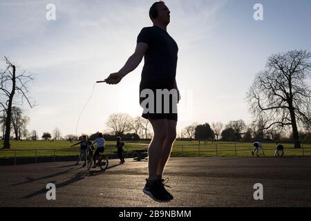 Le lendemain, le Premier ministre britannique Boris Johnson a imposé des restrictions de mouvement sans précédent à des millions de Britanniques qui devaient rester chez eux à moins que leurs emplois ou leurs voyages clés ne soient essentiels. Dit de prendre une seule séance d'exercice par jour, Russell indépendant qui a été déplacé de la salle de gym intérieure à Brockwell Lido, saute avec sa corde à sauter à un espace clair pour ceux qui souhaitent s'entraîner sur une surface douce, Là où les Londoniens du sud utilisent leur espace vert local pour une activité quotidienne à Brockwell Park à Herne Hill, le 24 mars 2020. Banque D'Images