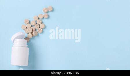 Pilules homéopathiques de toux mucaltine dans un pot sur un fond bleu, copier l'espace Banque D'Images