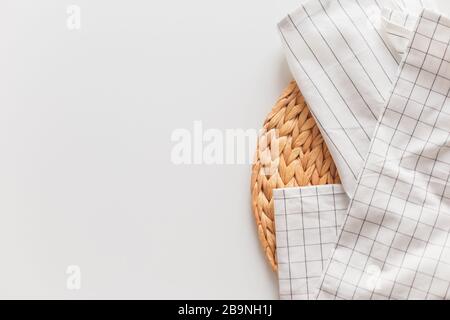 Nappe rayée et à carreaux blancs et gros plan en osier, isolée sur blanc avec espace de copie. Banque D'Images