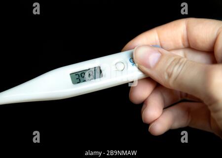 Tenir à la main un thermomètre présentant une forte fièvre de 39,9 °C. Banque D'Images