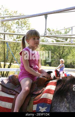 MEMPHIS, ÉTATS-UNIS - 21 avril 2006 : une petite fille fait du cheval à la ferme pendant le pique-nique. Banque D'Images