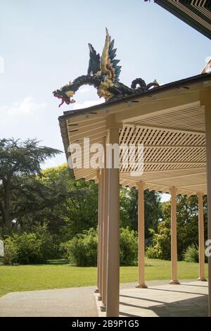 Rez-de-chaussée de la Grande Pagode restaurée, conçue par Sir William Chambers, montrant le profil d'un dragon en bois doré sur fond d'arbres. Banque D'Images