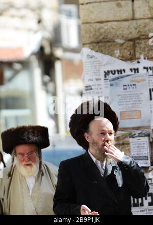 Un juif orthodoxe fume une cigarette. Banque D'Images