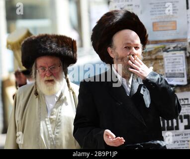 Un juif orthodoxe fume une cigarette. Banque D'Images