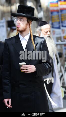 Un juif orthodoxe fume une cigarette. Banque D'Images