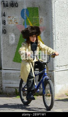 Un jeune garçon juif hassidique habillé comme un vieil homme juif hassidique pour le festival Purim dans le quartier de Mea Shearim à Jérusalem. Banque D'Images