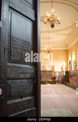 En traversant la lourde porte en bois de l'école supérieure, Eton College Banque D'Images