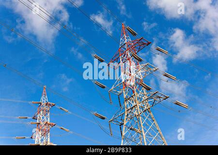 Power Line Pylons contre un ciel bleu nuageux, Toscane Italie Banque D'Images