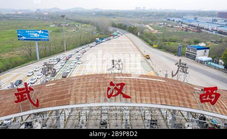 (200325) -- BEIJING, le 25 mars 2020 (Xinhua) -- la photo aérienne prise le 24 mars 2020 montre les véhicules de retour à Wuhan attendre de passer par une station de péage de l'autoroute à Wuhan, dans la province de Hubei en Chine centrale. Wuhan, la ville chinoise la plus durement touchée par la nouvelle épidémie de coronavirus, va lever les restrictions de voyage sortant à partir du 8 avril après plus de deux mois de verrouillage, ont déclaré les autorités locales mardi. Les habitants de Wuhan seront autorisés à quitter la ville et la province de Hubei, où Wuhan est la capitale, s'ils détiennent un code de santé vert, ce qui signifie qu'aucun contact avec les cas infectés ou soupçonnés de COVID-19, n'est conforme Banque D'Images