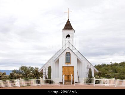 Petite église blanche rustique dans le désert paysage avec clôture de piquetage blanche autour de lui. Banque D'Images