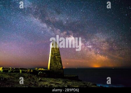 Portland Bill, Dorset, Royaume-Uni. 25 mars 2020. Météo britannique. La voie lactée brille dans le ciel clair de la nuit au-dessus de l'obélisque à Portland Bill à Dorset. Crédit photo : Graham Hunt/Alay Live News Banque D'Images