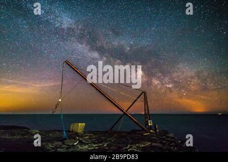 Portland Bill, Dorset, Royaume-Uni. 25 mars 2020. Météo britannique. La voie lactée brille dans le ciel clair de la nuit au-dessus d'une grue à Portland Bill à Dorset. Crédit photo : Graham Hunt/Alay Live News Banque D'Images