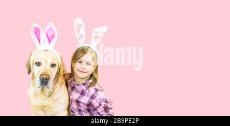 bannière de pâques adorable labrador retriever et jolie fille avec des oreilles de lapin sur fond rose avec espace de copie Banque D'Images