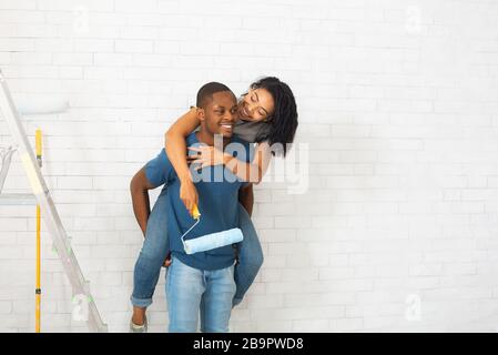 Couple millénaire afro-américain sur fond de mur de briques blanches Banque D'Images