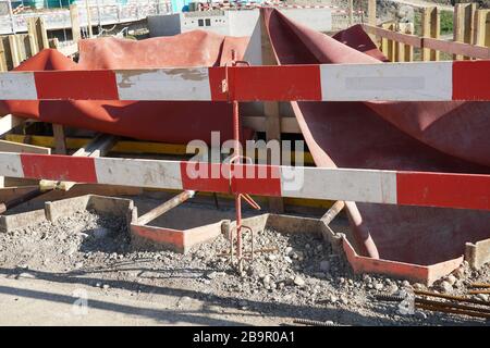 Planches de protection en rouge et blanc sur un bâtiment ou un chantier de génie civil ou de routes, à proximité. Banque D'Images