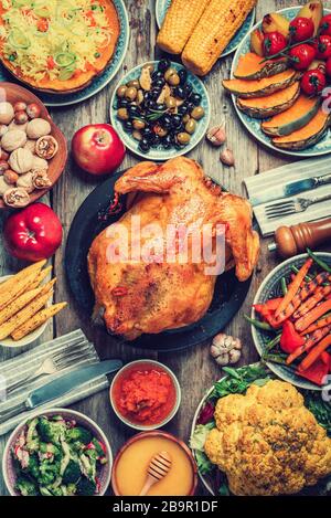Préparation du dîner de Thanksgiving. Plats traditionnels : poulet, citrouille, maïs, légumes salades sur fond de bois. Vue de dessus, espace de copie. A Banque D'Images