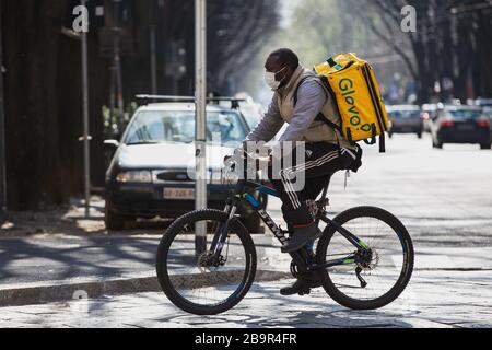 Glovo Food Delivery Man on Bike travailler avec le masque de protection pendant l'éclusage de Coronavirus en Italie Banque D'Images