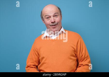 Homme chauve hispanique senior sur fond bleu Banque D'Images