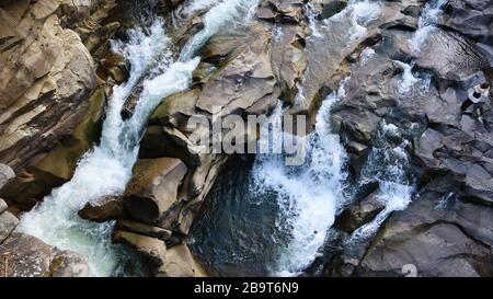 Vue du haut de la cascade. Vue de dessus du ruisseau, l'eau coule au-dessus des pierres. Cascade des montagnes rocheuses. Paysage aérien montagne rocheuse rivière en cascade Banque D'Images