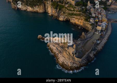 Photo aérienne prise avec un drone survolant l'église de San Pietro à Portovenere vue du côté de la mer avec les vagues se brisant sur la falaise pendant Banque D'Images