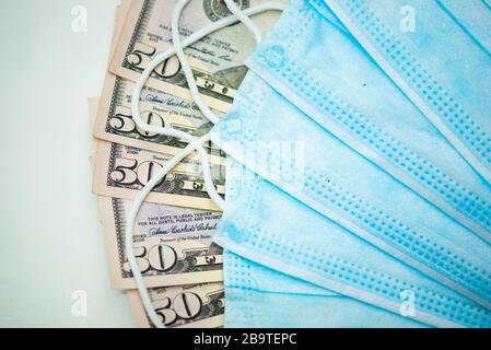 Masques de protection pour le visage avec factures en dollars. Spéculation et hausse des prix de la médecine. Des affaires pour la santé des gens. COVID 19 Coronavirus Banque D'Images