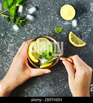 Woman's hands holding une tasse de cuivre de limonade à la menthe fraîche, vue du dessus Banque D'Images