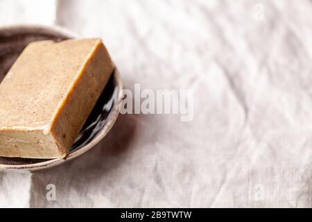 Savon naturel aux légumes fait à la main avec herbes et avoine sur fond textile gros plan. Produits de soins biologiques spa. Orientation horizontale, copier l'image d'axe Banque D'Images