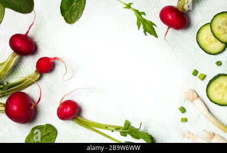 Légumes de printemps sur fond en bois avec espace de copie. Radis, concombre, salade verte et oignon vert - récolte fraîche du jardin Banque D'Images