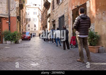 ROME, ITALIE - 12 mars 2020: Les clients se trouvent en dehors d'un supermarché local dans le centre de Rome, Italie. Seulement quelques personnes peuvent entrer à la fois, et shal Banque D'Images