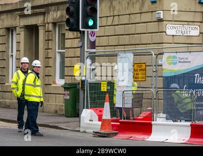 Leith, Édimbourg, Écosse, Royaume-Uni. 25 mars 2020. Tramways pour les travaux de construction de Newhaven : certains ouvriers continuent de travailler sur Constitution Street malgré l'appel du gouvernement écossais à cesser les travaux de construction pendant la pandémie de Coronavirus du Covid-19 Banque D'Images