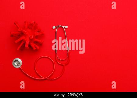 Résumé virus Strain Model et stéthoscope sur fond rouge. Quarantaine du virus Corona. Concept de protection contre la pandémie de virus Banque D'Images