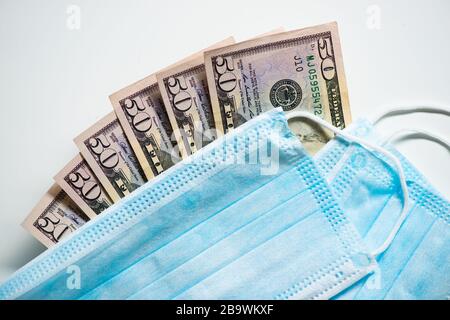 Masques de protection pour le visage avec factures en dollars. Spéculation et hausse des prix de la médecine. Des affaires pour la santé des gens. COVID 19 Coronavirus Banque D'Images