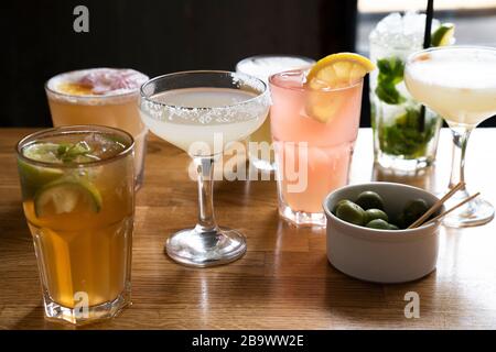 Beaucoup de cocktails différents sur le bar en bois avec fond noir. Banque D'Images