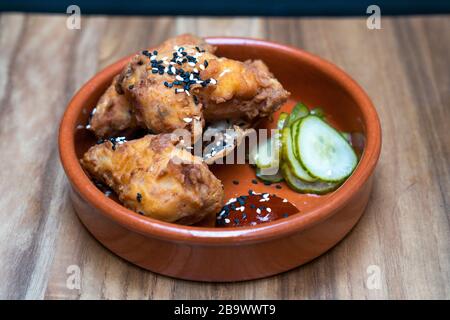 Ailes de poulet coréen, sauce au Chili fermenté et concombre mariné Banque D'Images