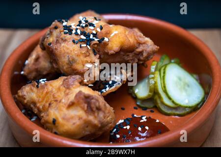 Ailes de poulet coréen, sauce au Chili fermenté et concombre mariné Banque D'Images